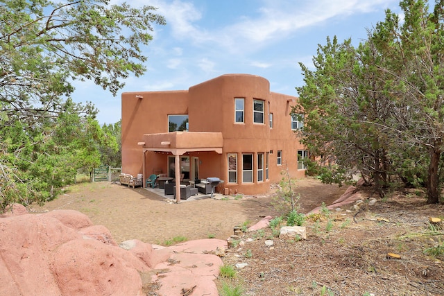 rear view of house with a patio and outdoor lounge area