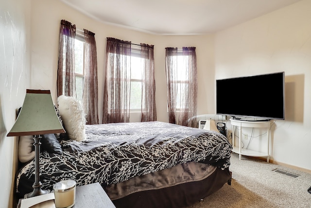 carpeted bedroom featuring multiple windows