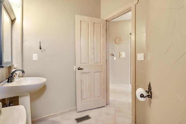 bathroom featuring sink, toilet, and tile patterned floors