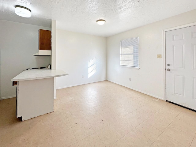 unfurnished living room with a textured ceiling and light tile floors