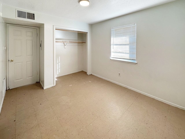 unfurnished bedroom featuring a closet, a textured ceiling, and light tile flooring