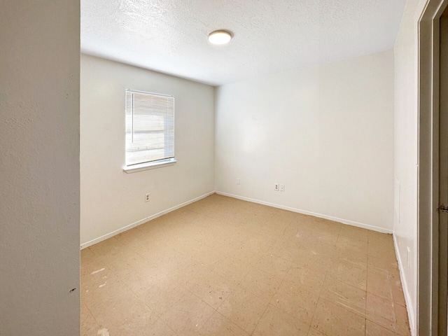 tiled empty room with a textured ceiling