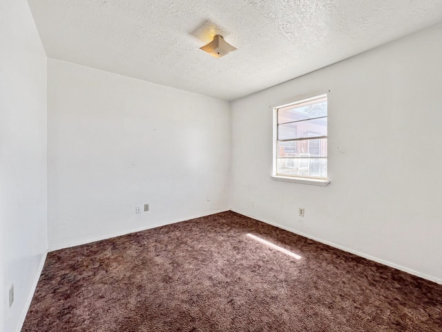 empty room with a textured ceiling and carpet flooring