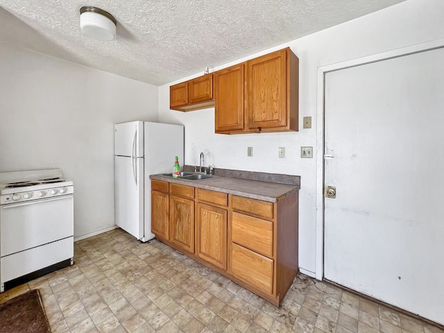 kitchen with a textured ceiling, sink, light tile flooring, and white appliances