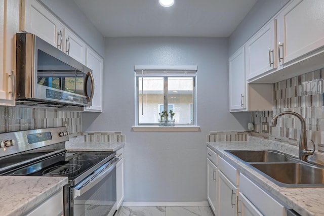 kitchen featuring white cabinets, backsplash, and stainless steel appliances