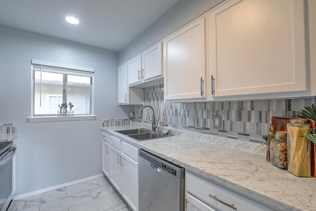 kitchen with light stone countertops, tasteful backsplash, stainless steel appliances, sink, and white cabinetry