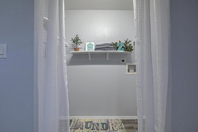 washroom with hookup for a washing machine, electric dryer hookup, and hardwood / wood-style floors