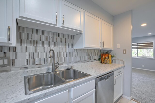 kitchen with dishwasher, sink, tasteful backsplash, light carpet, and white cabinets