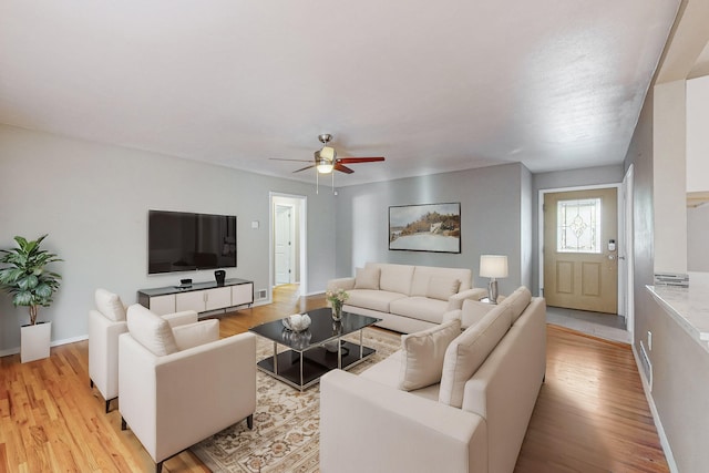 living room featuring ceiling fan and light hardwood / wood-style floors