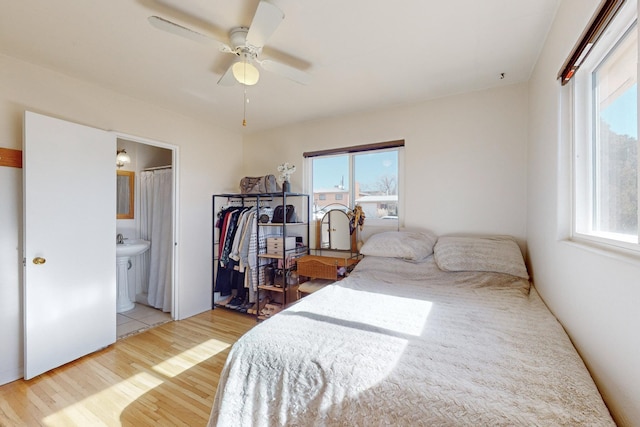 bedroom with ceiling fan, light wood-type flooring, and ensuite bathroom