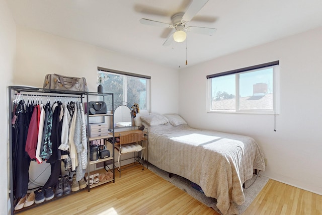 bedroom with ceiling fan, light wood-type flooring, and multiple windows