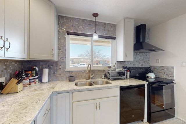 kitchen featuring black appliances, sink, white cabinetry, wall chimney range hood, and decorative light fixtures