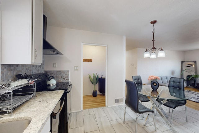 dining area with light hardwood / wood-style floors, a chandelier, and sink