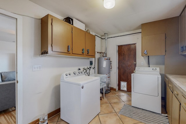 washroom with independent washer and dryer, cabinets, light tile patterned flooring, and gas water heater