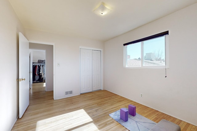 unfurnished bedroom with a closet and light hardwood / wood-style floors