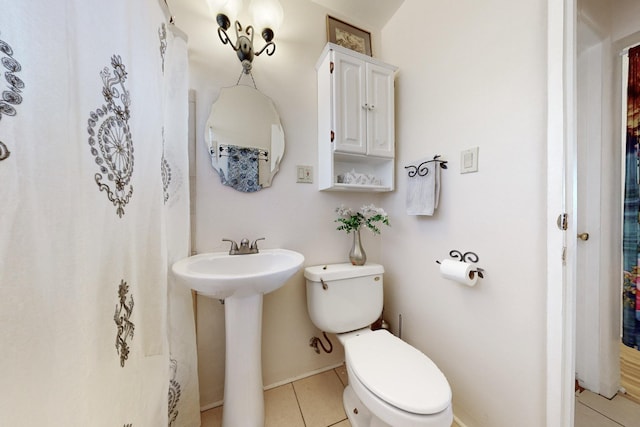 bathroom with toilet, tile patterned floors, and sink