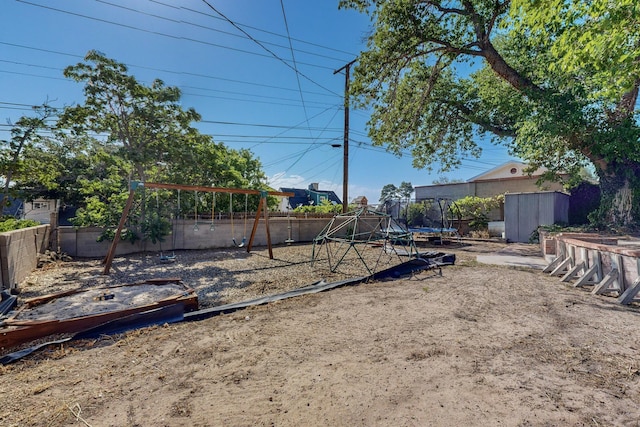 view of yard with a playground, a shed, and a trampoline