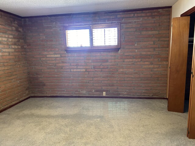 empty room with brick wall and a textured ceiling