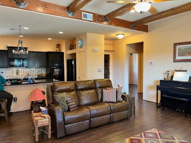 living room featuring ceiling fan, beam ceiling, and dark hardwood / wood-style flooring