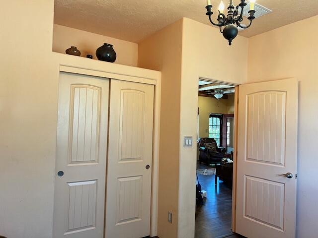 hallway with a notable chandelier and hardwood / wood-style floors