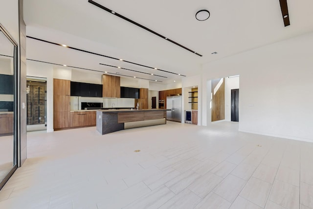 unfurnished living room with sink and built in features