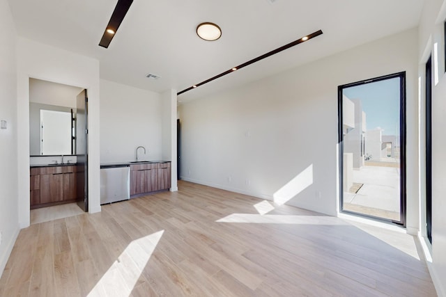 empty room featuring sink and light wood-type flooring