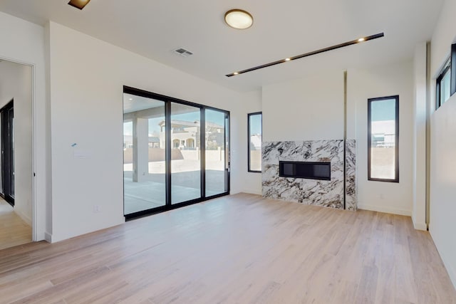 living room featuring a premium fireplace and light wood-type flooring