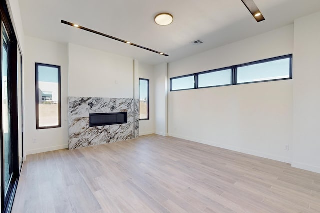 living room featuring light wood-type flooring and a fireplace