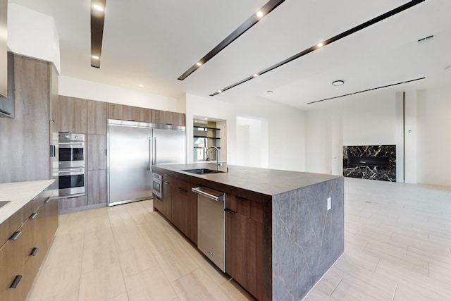 kitchen featuring built in appliances, sink, and a spacious island