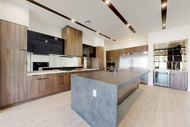 kitchen featuring beverage cooler, a spacious island, and appliances with stainless steel finishes