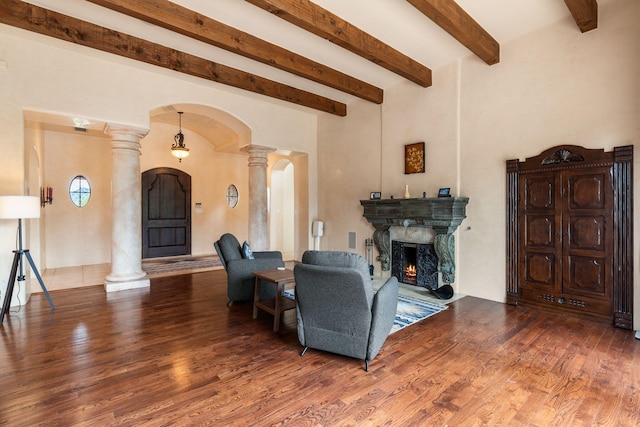 living room featuring decorative columns, beamed ceiling, and wood-type flooring