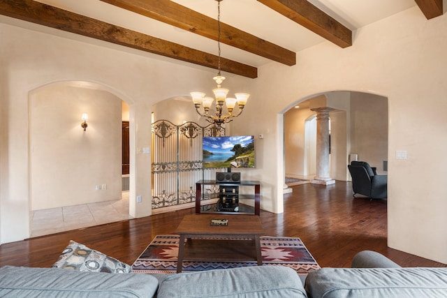 living room with beam ceiling, ornate columns, a chandelier, and wood-type flooring