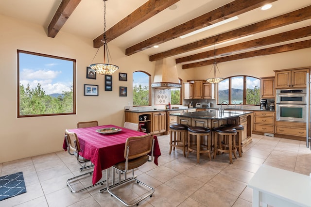 dining space featuring sink, beamed ceiling, and light tile patterned flooring