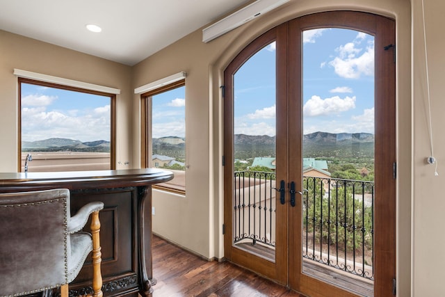 doorway to outside featuring a water and mountain view, dark hardwood / wood-style flooring, and french doors