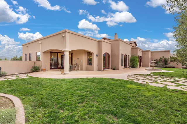 rear view of property featuring a yard and a patio