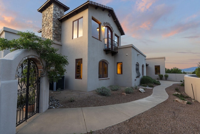 property exterior at dusk with a balcony