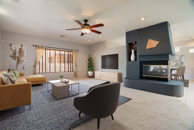 living room with a multi sided fireplace, ceiling fan, and tile patterned flooring