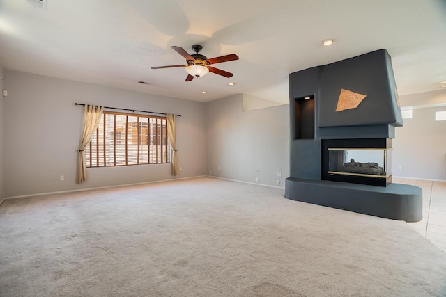 unfurnished living room with carpet flooring, ceiling fan, and a multi sided fireplace