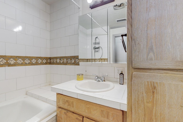 bathroom featuring decorative backsplash, vanity, and a bathtub