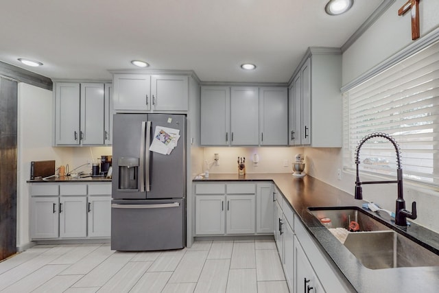 kitchen with gray cabinetry, stainless steel fridge, and sink