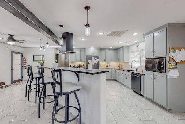 kitchen featuring gray cabinetry, pendant lighting, sink, island range hood, and stainless steel appliances