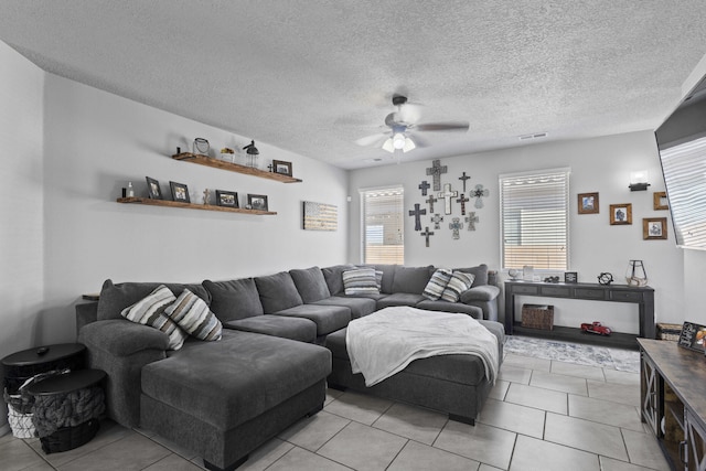 tiled living room with ceiling fan and a textured ceiling