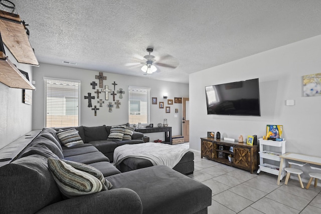 living room featuring a textured ceiling, ceiling fan, and light tile patterned flooring