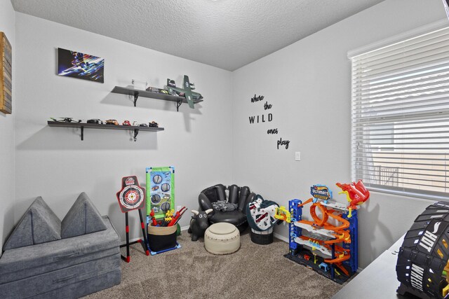 playroom with carpet flooring and a textured ceiling