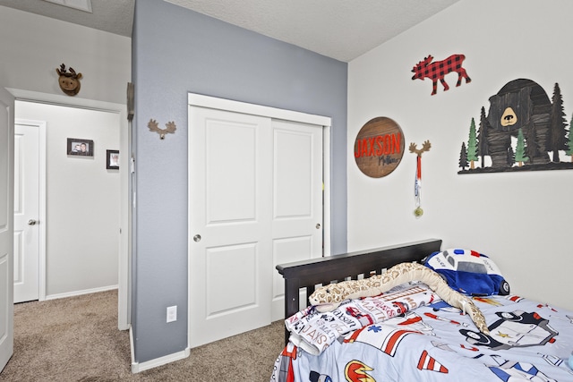 carpeted bedroom with a textured ceiling and a closet