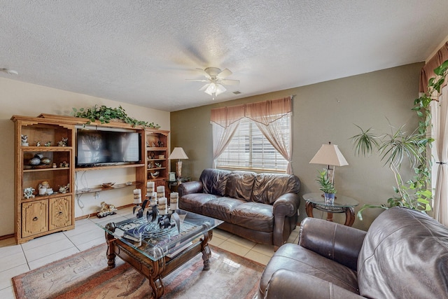 living room with ceiling fan, light tile patterned flooring, and a textured ceiling