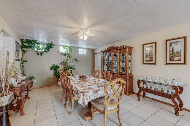 tiled dining space with ceiling fan and a textured ceiling