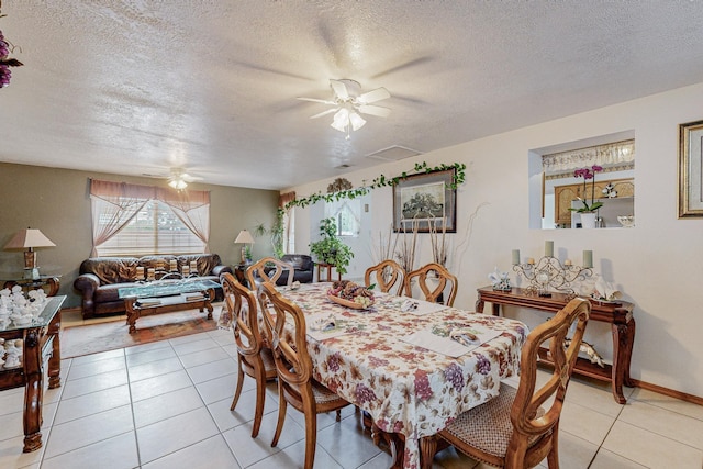 tiled dining room with ceiling fan and a textured ceiling