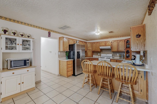 kitchen featuring a kitchen breakfast bar, sink, tasteful backsplash, and appliances with stainless steel finishes