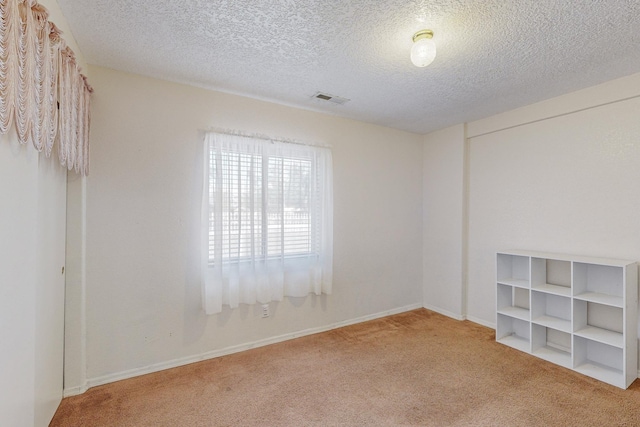 carpeted spare room featuring a textured ceiling